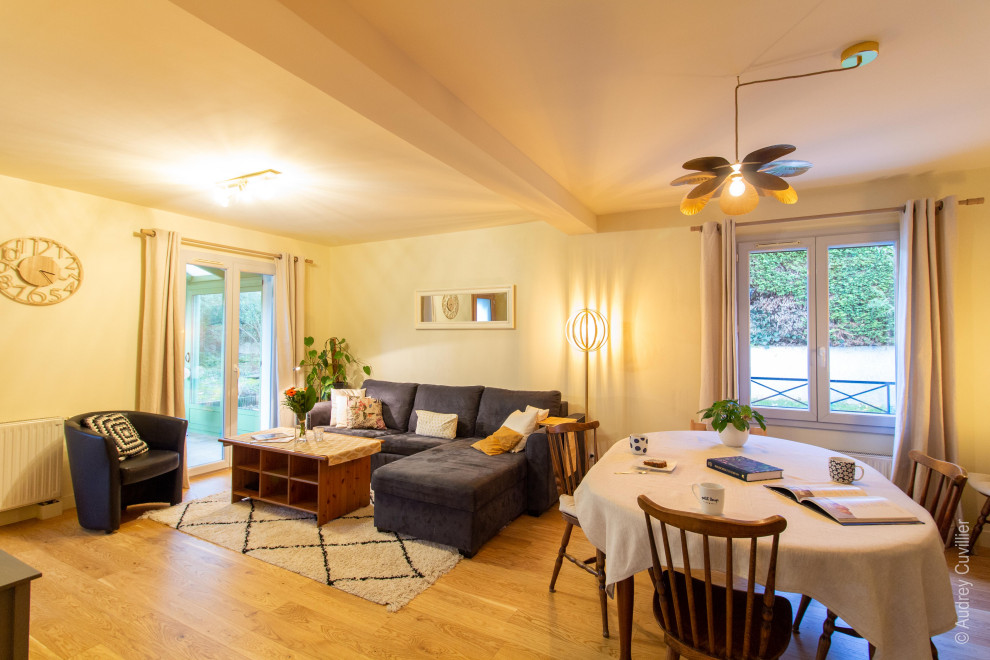 Imagen de sala de estar abierta mediterránea de tamaño medio con paredes beige y suelo de madera clara
