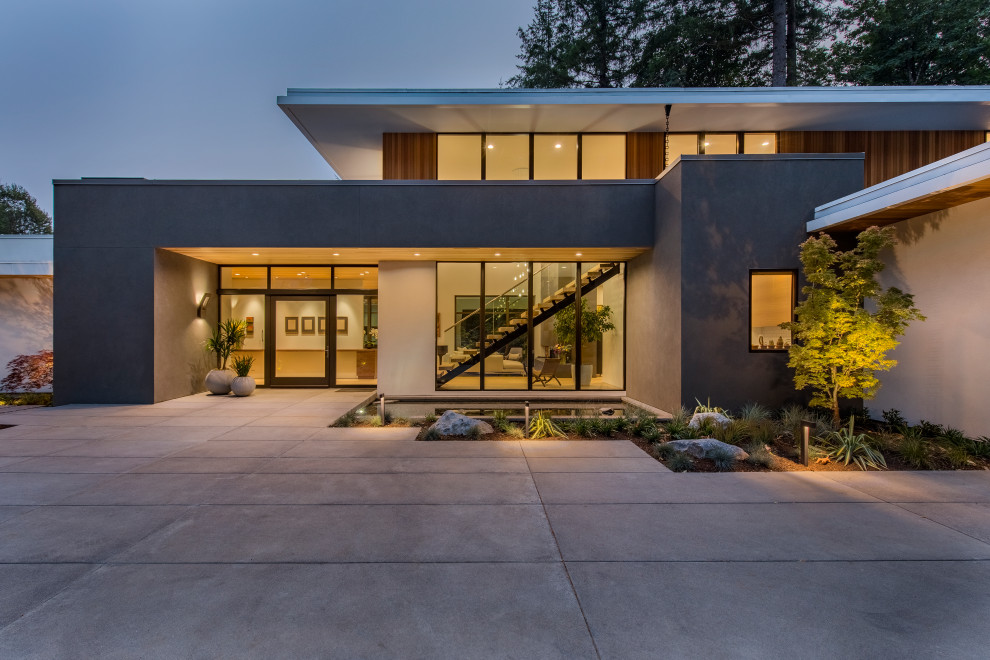 This is an example of a contemporary two-storey white house exterior in Portland with wood siding, a flat roof and a mixed roof.