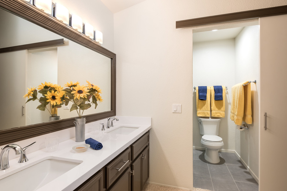 Photo of a large transitional master bathroom in San Diego with recessed-panel cabinets, medium wood cabinets, an alcove shower, a two-piece toilet, gray tile, ceramic tile, beige walls, ceramic floors, a drop-in sink and quartzite benchtops.