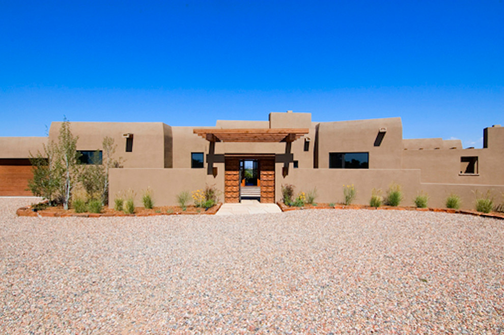 Inspiration for a mid-sized one-storey stucco beige exterior in Albuquerque with a flat roof.