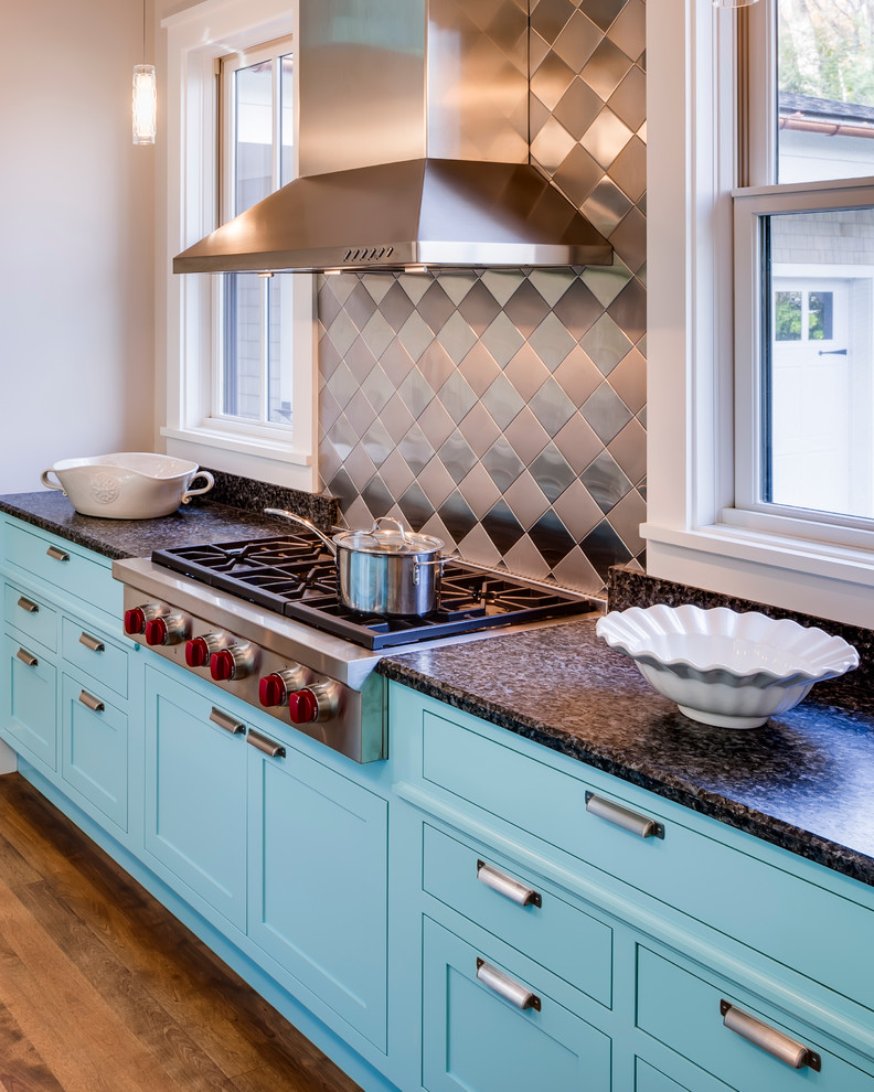 Inspiration for a mid-sized contemporary galley open plan kitchen in Portland Maine with an undermount sink, shaker cabinets, turquoise cabinets, laminate benchtops, metallic splashback, metal splashback, stainless steel appliances, dark hardwood floors and with island.