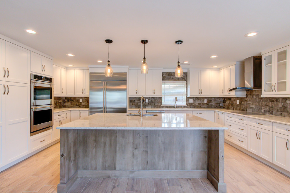 Enclosed kitchen - large transitional u-shaped porcelain tile and brown floor enclosed kitchen idea with an undermount sink, shaker cabinets, white cabinets, quartz countertops, brown backsplash, stainless steel appliances, an island and beige countertops