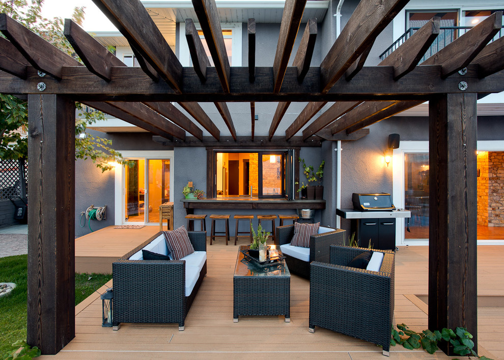 This is an example of a traditional patio in Vancouver with decking and a pergola.