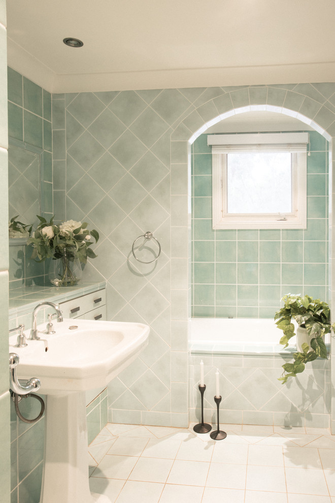 Mid-sized traditional master bathroom in Sydney with flat-panel cabinets, blue cabinets, a drop-in tub, an alcove shower, a wall-mount toilet, green tile, ceramic tile, green walls, porcelain floors, a pedestal sink, tile benchtops, blue floor, a hinged shower door and green benchtops.