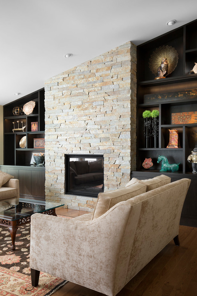 Photo of a large transitional formal enclosed living room in Calgary with beige walls, medium hardwood floors, a standard fireplace, a stone fireplace surround, no tv and brown floor.