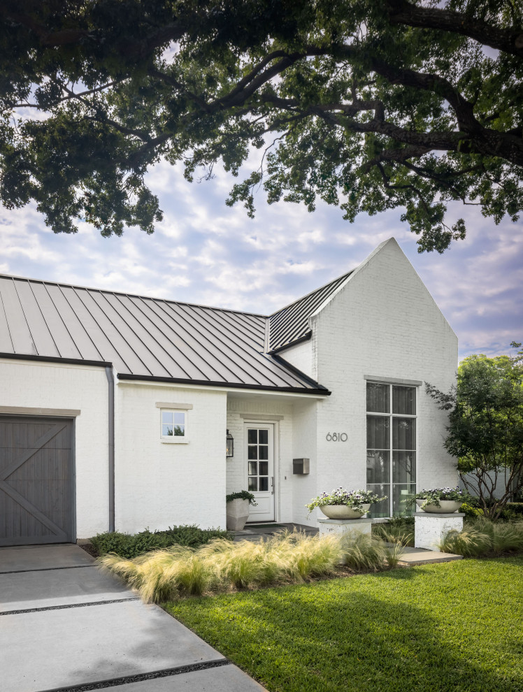 Großes, Einstöckiges Klassisches Einfamilienhaus mit gestrichenen Ziegeln, weißer Fassadenfarbe, Satteldach, Blechdach und grauem Dach in Dallas