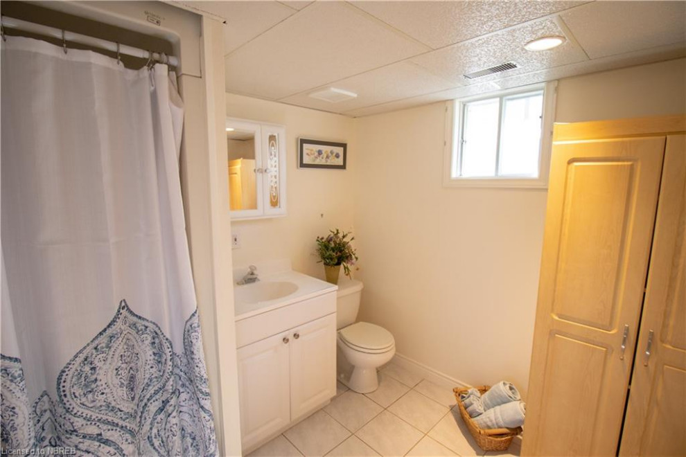 Small contemporary 3/4 bathroom in Other with raised-panel cabinets, white cabinets, an alcove shower, a two-piece toilet, beige walls, ceramic floors, an integrated sink, solid surface benchtops, beige floor, a shower curtain, white benchtops, a single vanity and a freestanding vanity.