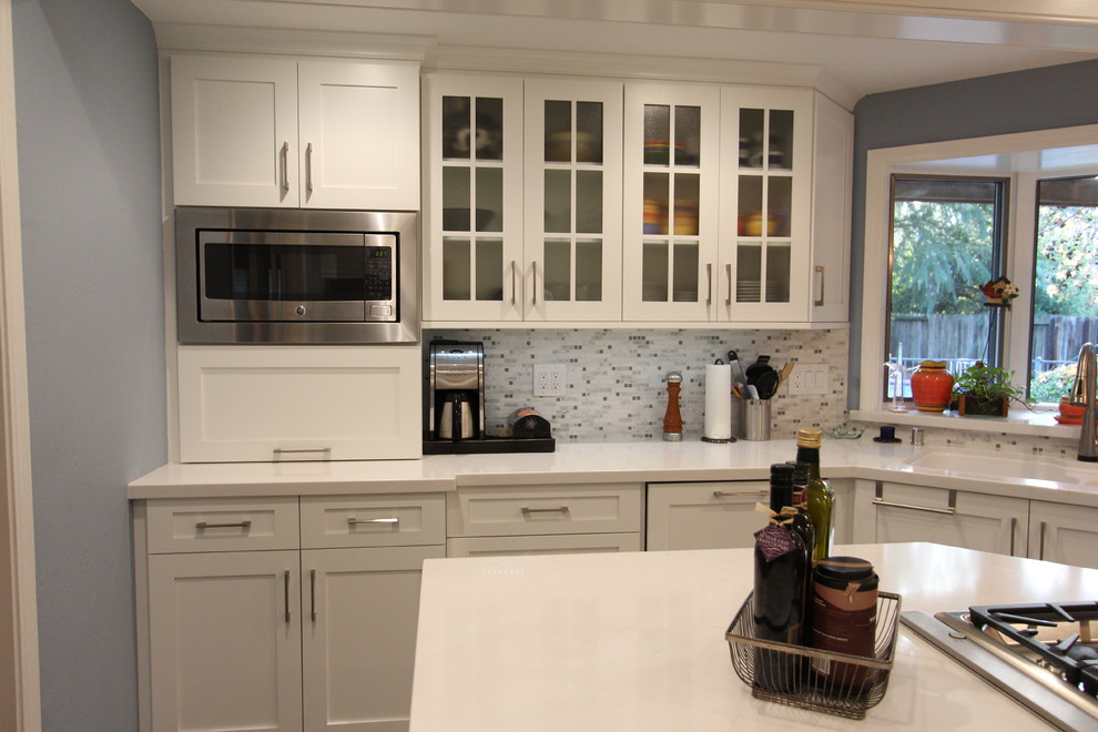 Design ideas for a mid-sized traditional u-shaped eat-in kitchen in San Francisco with an undermount sink, shaker cabinets, white cabinets, quartz benchtops, grey splashback, glass tile splashback, stainless steel appliances, marble floors and with island.