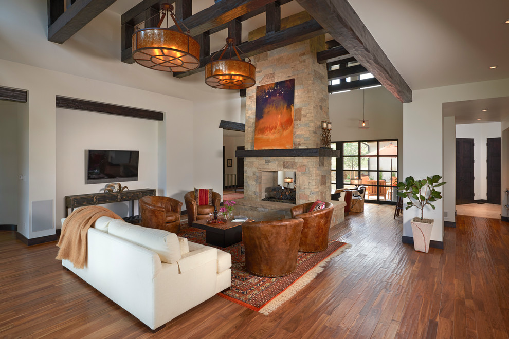 Inspiration for a large modern open concept family room in Denver with white walls, medium hardwood floors, a two-sided fireplace, a stone fireplace surround and a wall-mounted tv.
