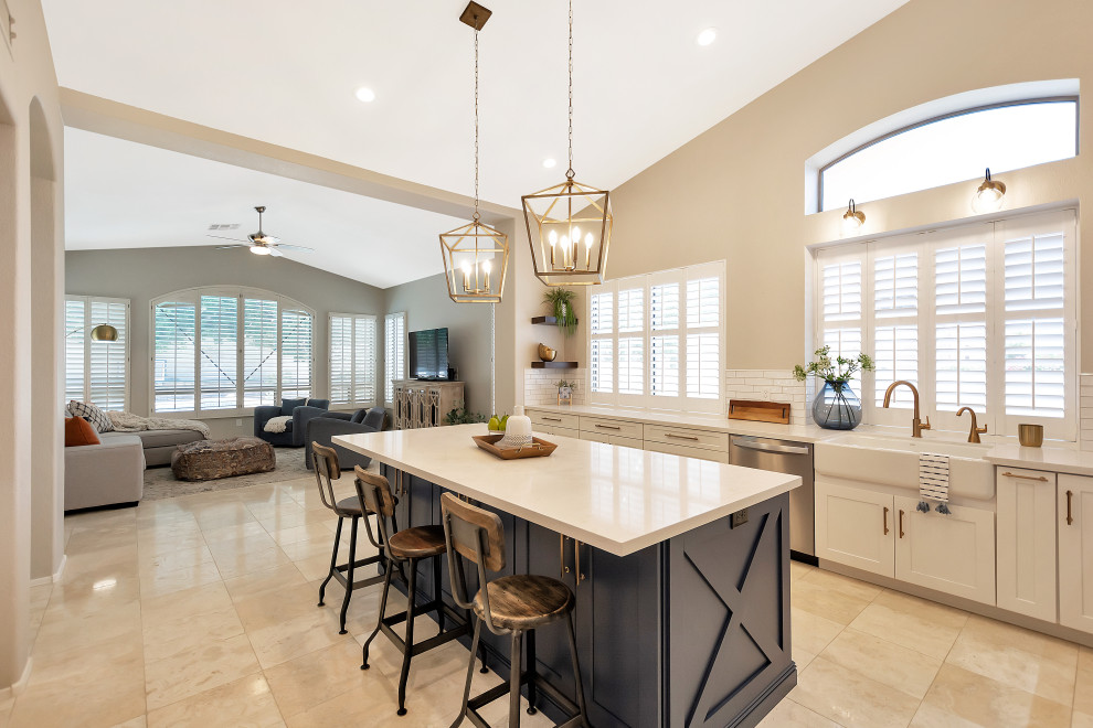 Large transitional u-shaped open concept kitchen photo in Phoenix with a farmhouse sink, shaker cabinets, white cabinets, quartz countertops, white backsplash, subway tile backsplash, stainless steel appliances, an island and white countertops