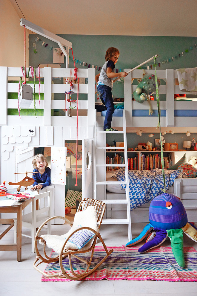 Large scandinavian gender-neutral kids' bedroom in Hamburg with light hardwood floors and multi-coloured walls for kids 4-10 years old.