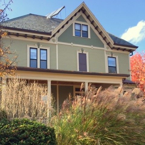 Inspiration for a large traditional two-storey green exterior in Boston with wood siding.