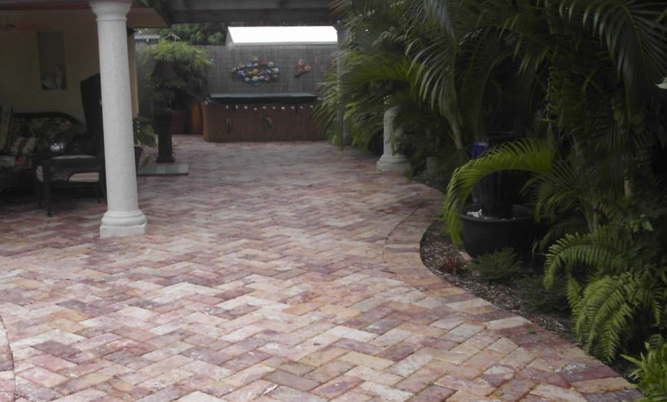 Photo of a large mediterranean backyard patio in Miami with natural stone pavers and a roof extension.