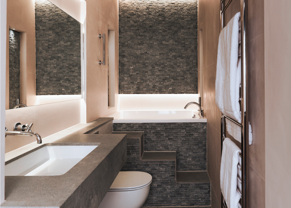 This is an example of a small contemporary kids bathroom in Other with a japanese tub, a wall-mount toilet, a single vanity, gray tile, grey walls, an undermount sink, grey benchtops and a floating vanity.