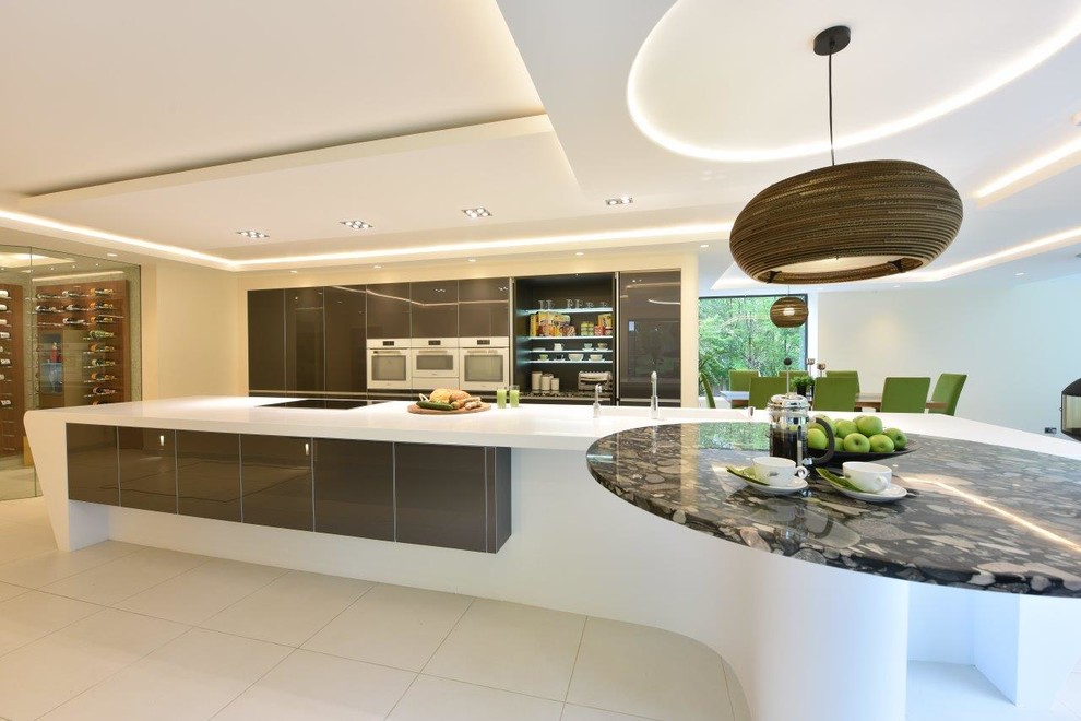Expansive modern kitchen in Manchester with an integrated sink, glass-front cabinets, grey cabinets, solid surface benchtops, white appliances, porcelain floors, with island, white floor and white benchtop.