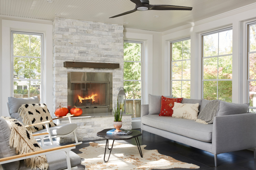 This is an example of a large transitional sunroom in Minneapolis with porcelain floors, a metal fireplace surround, a standard ceiling and a standard fireplace.