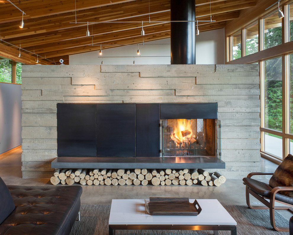 Photo of a mid-sized contemporary open concept living room in Portland with blue walls, concrete floors, a two-sided fireplace, a concrete fireplace surround and grey floor.