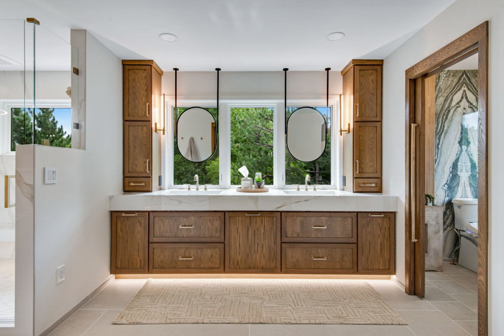 Example of a huge transitional master white tile and stone slab porcelain tile, beige floor, double-sink and wall paneling freestanding bathtub design in Denver with recessed-panel cabinets, medium tone wood cabinets, a two-piece toilet, white walls, an integrated sink, solid surface countertops, a hinged shower door, white countertops and a floating vanity