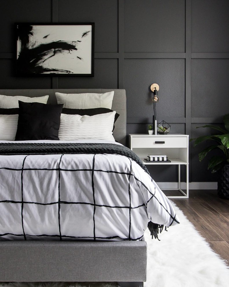 Photo of a transitional bedroom in Miami with black walls and brown floor.