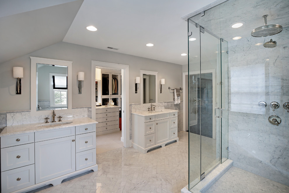 Inspiration for a large traditional master bathroom in Chicago with recessed-panel cabinets, white cabinets, a freestanding tub, white tile, grey walls, ceramic floors, an undermount sink, a corner shower, marble, marble benchtops and a hinged shower door.