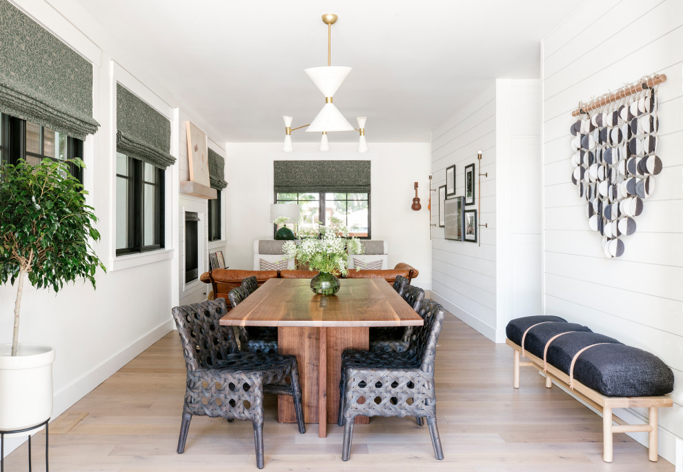 Photo of a beach style open plan dining in San Francisco with white walls, light hardwood floors, beige floor and planked wall panelling.