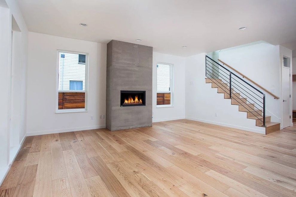 Mid-sized modern formal enclosed living room in Portland with white walls, light hardwood floors, a standard fireplace, a tile fireplace surround, no tv and brown floor.
