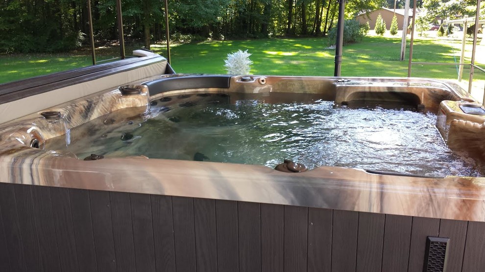 Photo of a small traditional backyard rectangular aboveground pool in Other with a hot tub.