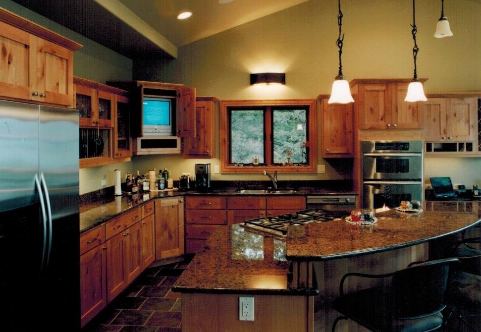 Example of a large mountain style l-shaped slate floor kitchen design with an undermount sink, shaker cabinets, light wood cabinets, granite countertops, stainless steel appliances and an island