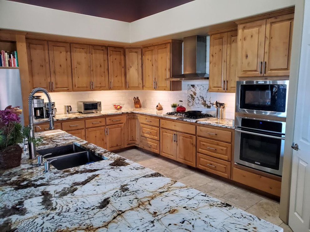Inspiration for a large rustic l-shaped slate floor, gray floor and vaulted ceiling kitchen pantry remodel in Phoenix with an undermount sink, shaker cabinets, light wood cabinets, granite countertops, white backsplash, subway tile backsplash, stainless steel appliances, an island and multicolored countertops