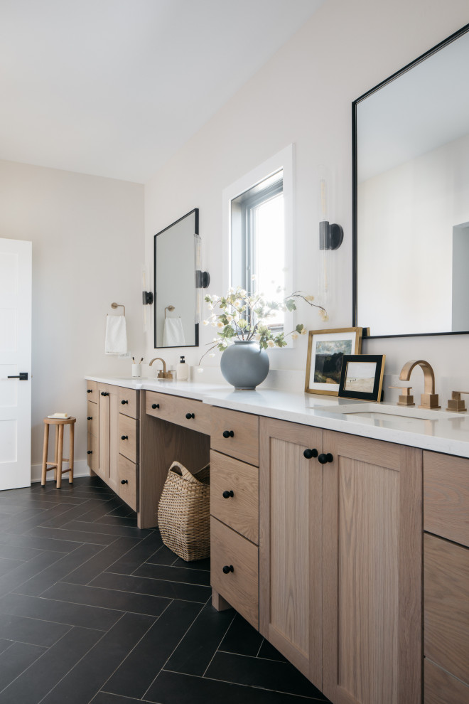 Réalisation d'une salle de bain tradition en bois clair avec un placard à porte shaker, un mur beige, un lavabo encastré, un sol noir, un plan de toilette blanc, meuble double vasque et meuble-lavabo encastré.