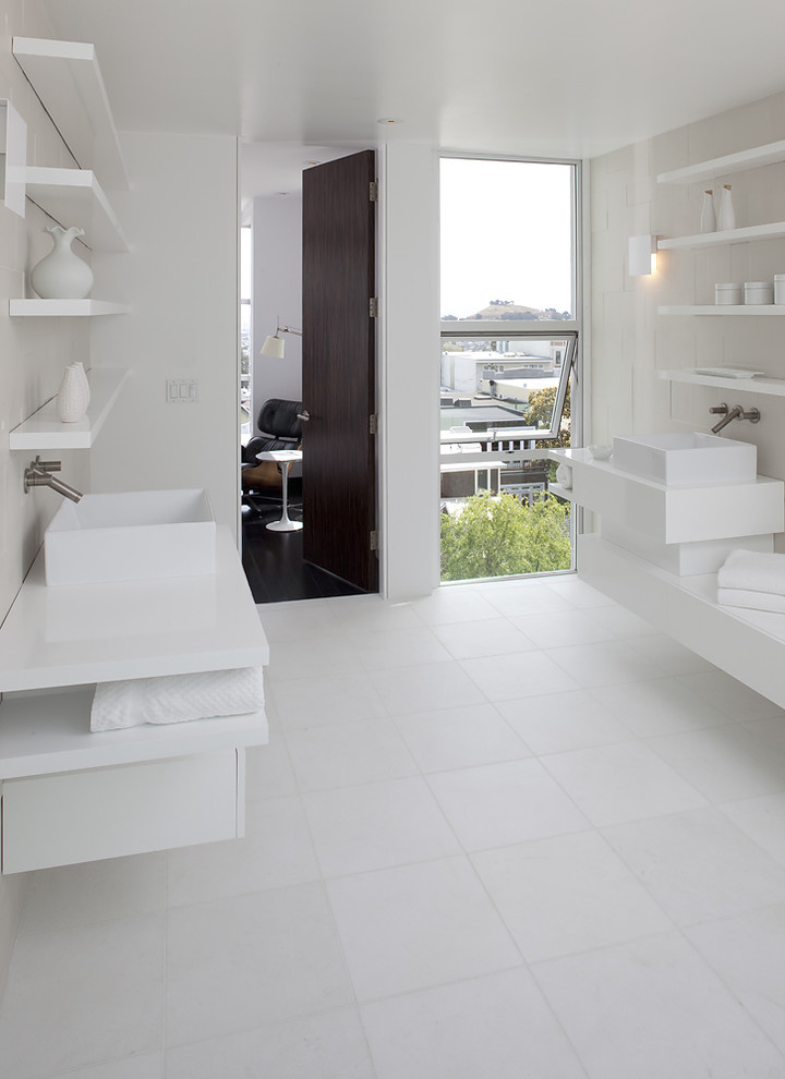Modern bathroom in San Francisco with a vessel sink, open cabinets, white cabinets, white tile and white floor.