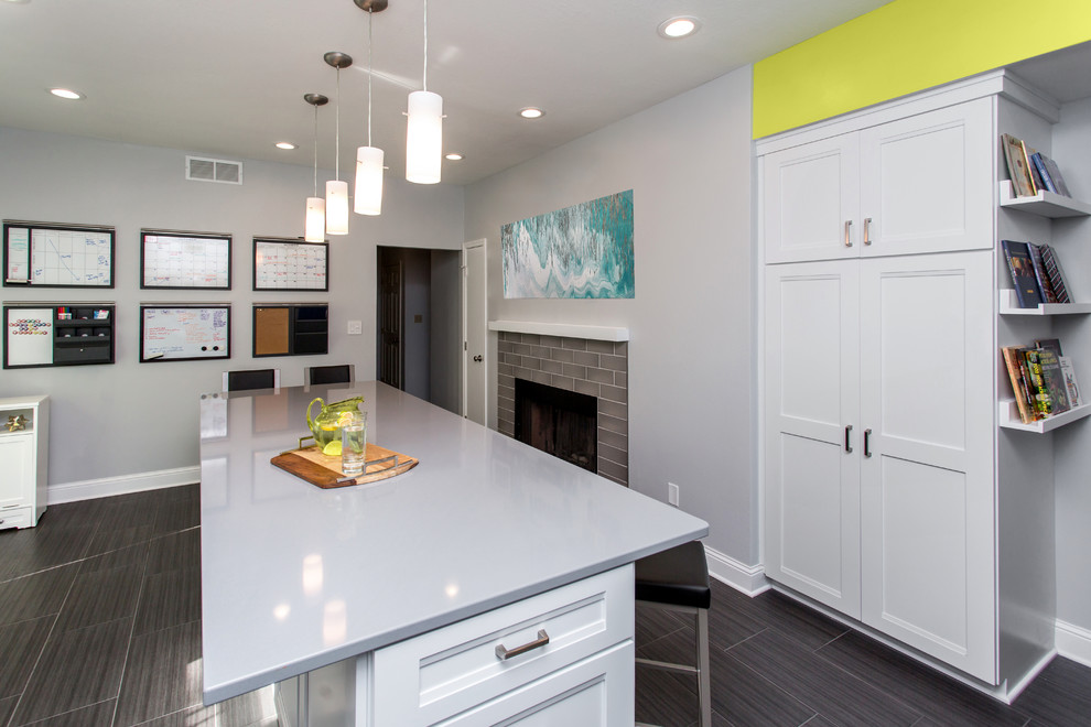 Mid-sized transitional u-shaped porcelain tile enclosed kitchen photo with a drop-in sink, recessed-panel cabinets, white cabinets, quartz countertops, gray backsplash, ceramic backsplash, stainless steel appliances and an island