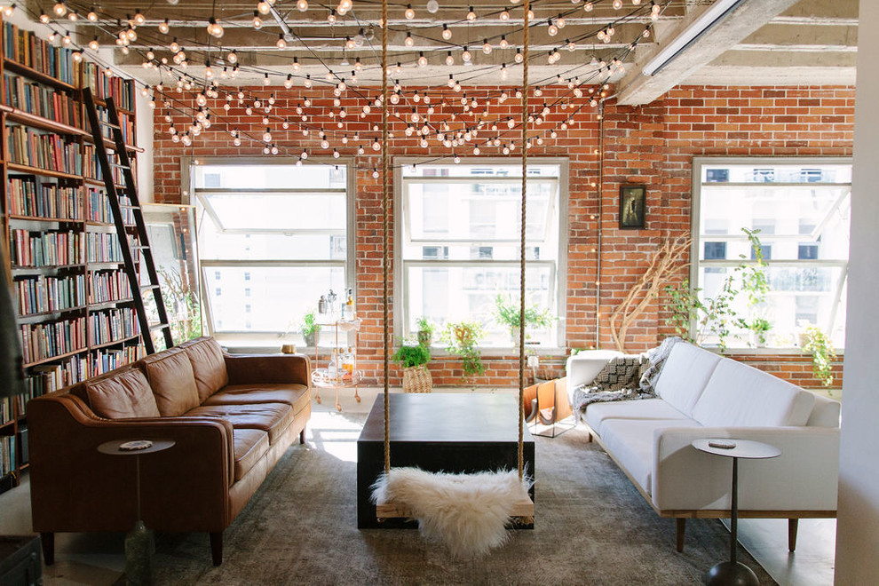 Living room library - small industrial open concept concrete floor living room library idea with red walls and no fireplace