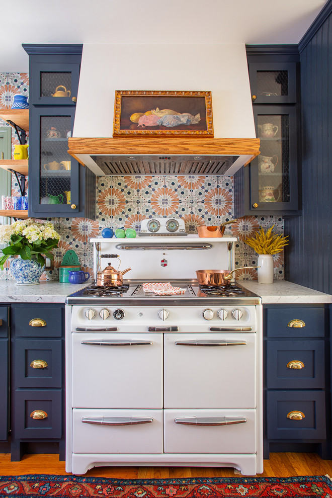 This is an example of a mid-sized eclectic galley separate kitchen in Los Angeles with shaker cabinets, blue cabinets, marble benchtops, multi-coloured splashback, porcelain splashback, white appliances, medium hardwood floors and white benchtop.