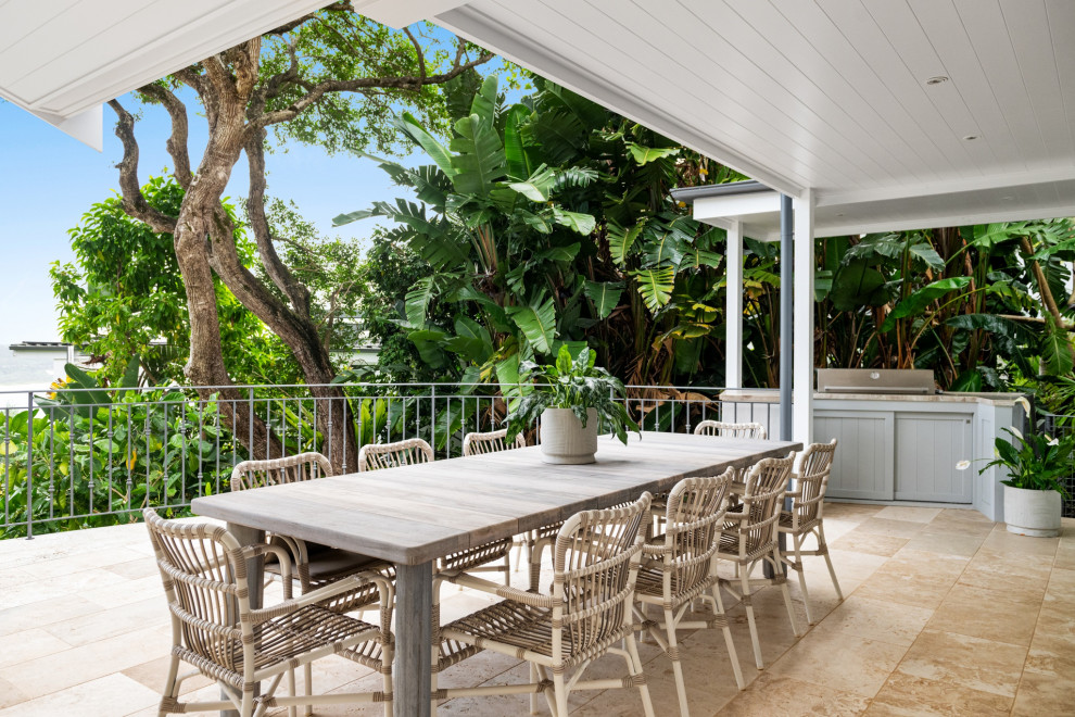 Beach style patio in Sydney with tile and a roof extension.