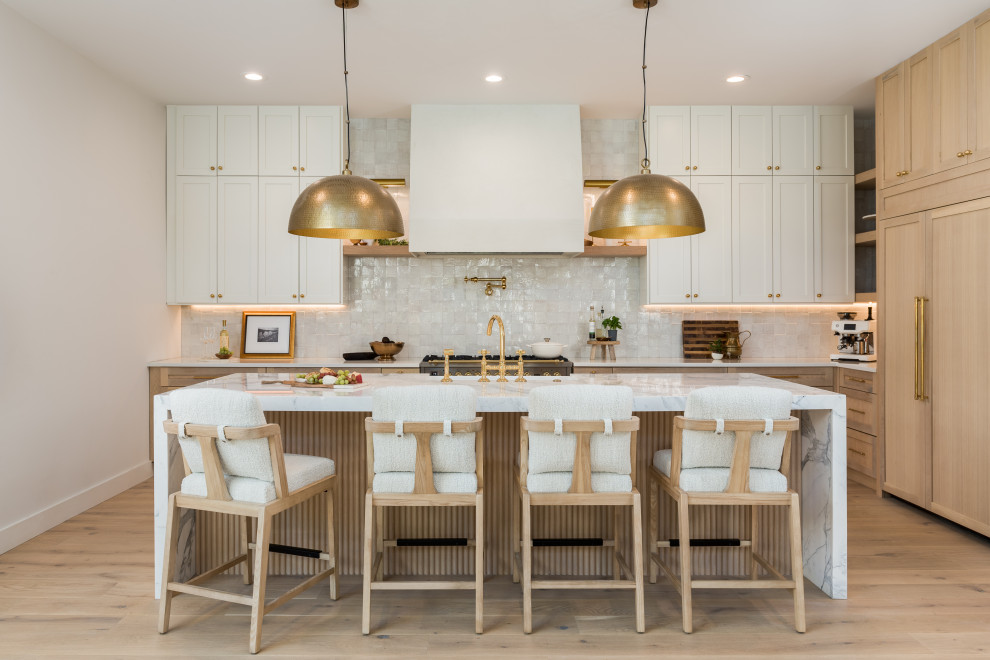 Kitchen - transitional l-shaped light wood floor and beige floor kitchen idea in Tampa with a farmhouse sink, shaker cabinets, white cabinets, white backsplash, paneled appliances, an island and white countertops