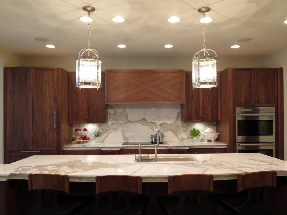 Eat-in kitchen - mid-sized transitional single-wall beige floor eat-in kitchen idea in Chicago with an undermount sink, flat-panel cabinets, medium tone wood cabinets, marble countertops, white backsplash, marble backsplash, paneled appliances and an island