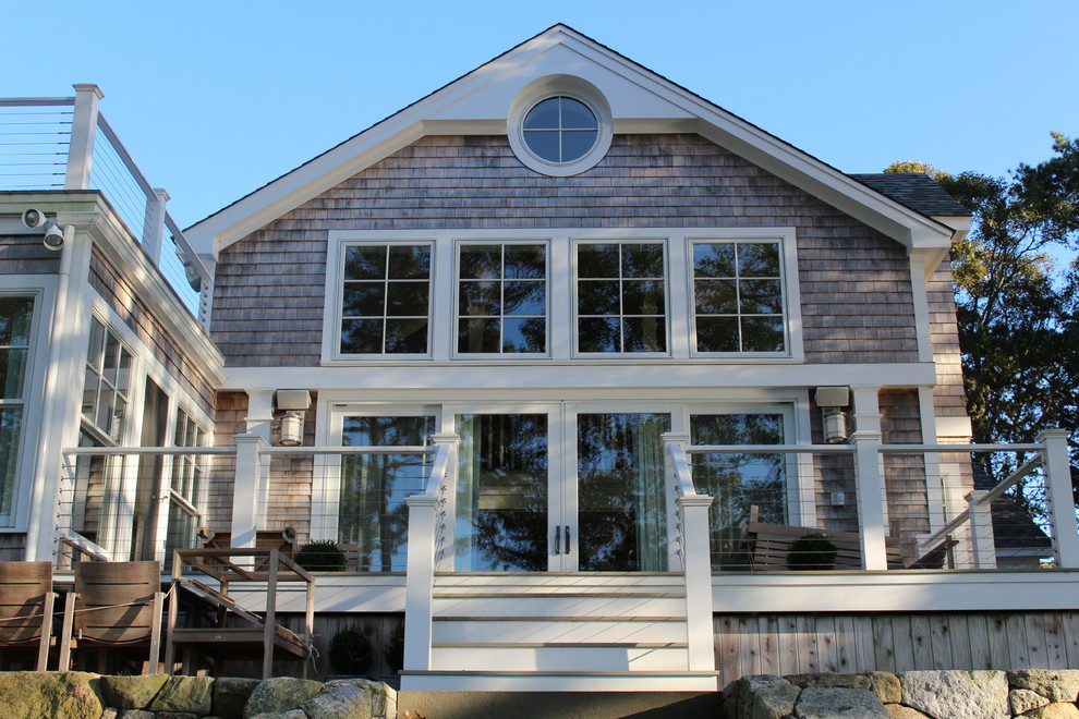 This is an example of a large beach style two-storey grey house exterior in Boston with wood siding, a gable roof and a shingle roof.