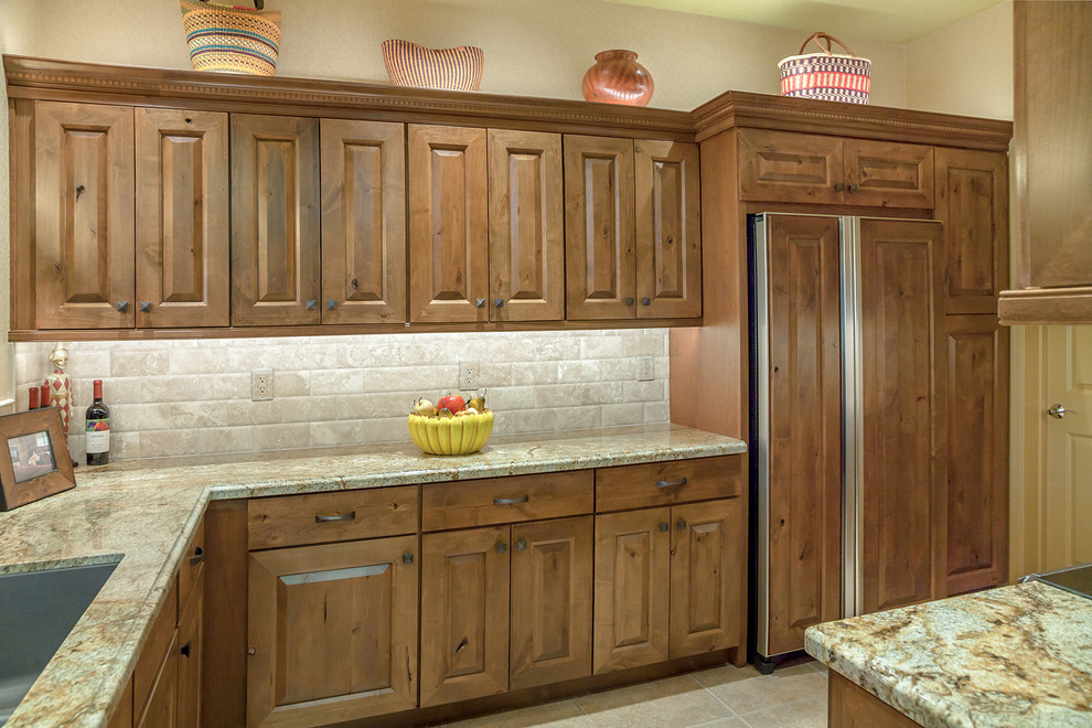 Inspiration for a mid-sized transitional l-shaped porcelain tile and beige floor open concept kitchen remodel in Phoenix with an undermount sink, raised-panel cabinets, medium tone wood cabinets, granite countertops, beige backsplash, travertine backsplash and paneled appliances