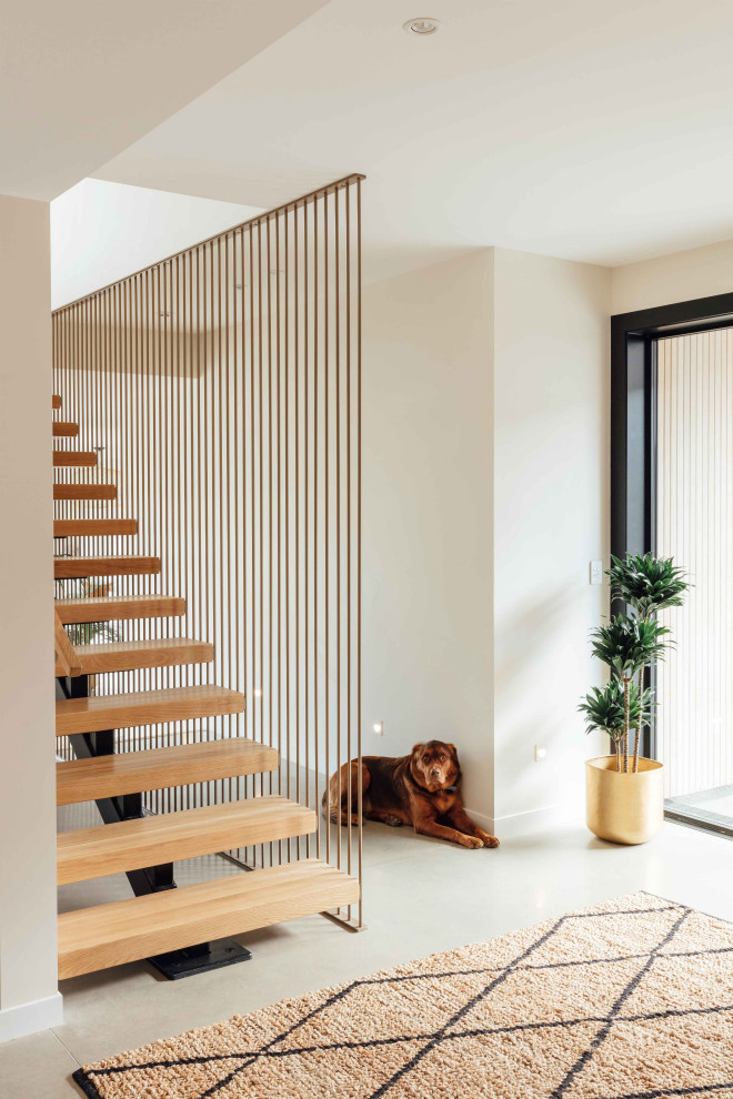 Large trendy wooden floating staircase photo in Auckland