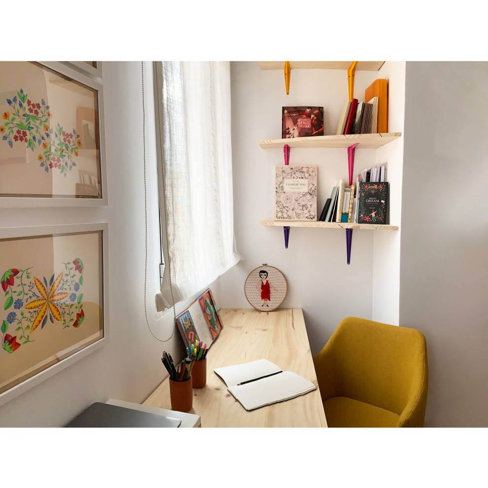 Bohemian home studio in Madrid with white walls, medium hardwood flooring and a built-in desk.
