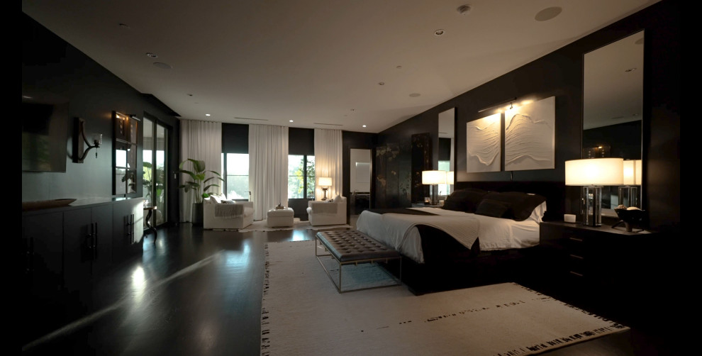 Geräumiges Modernes Hauptschlafzimmer mit schwarzer Wandfarbe, dunklem Holzboden, schwarzem Boden und Tapetenwänden in Dallas