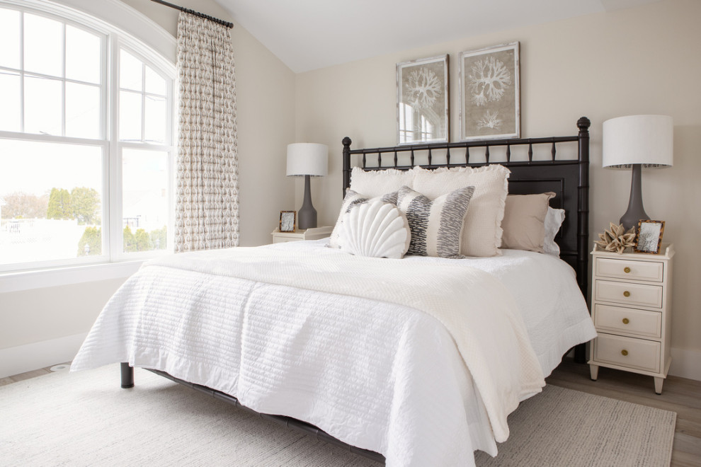 Photo of a large beach style guest bedroom in Boston with beige walls, light hardwood floors and vaulted.