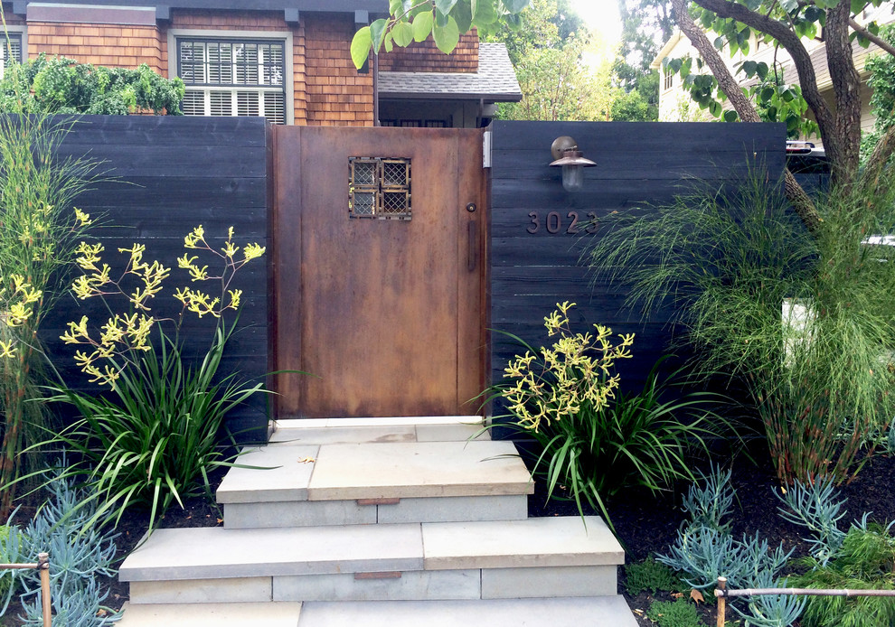 Photo of a modern front yard partial sun garden for spring in San Francisco with with a gate and natural stone pavers.
