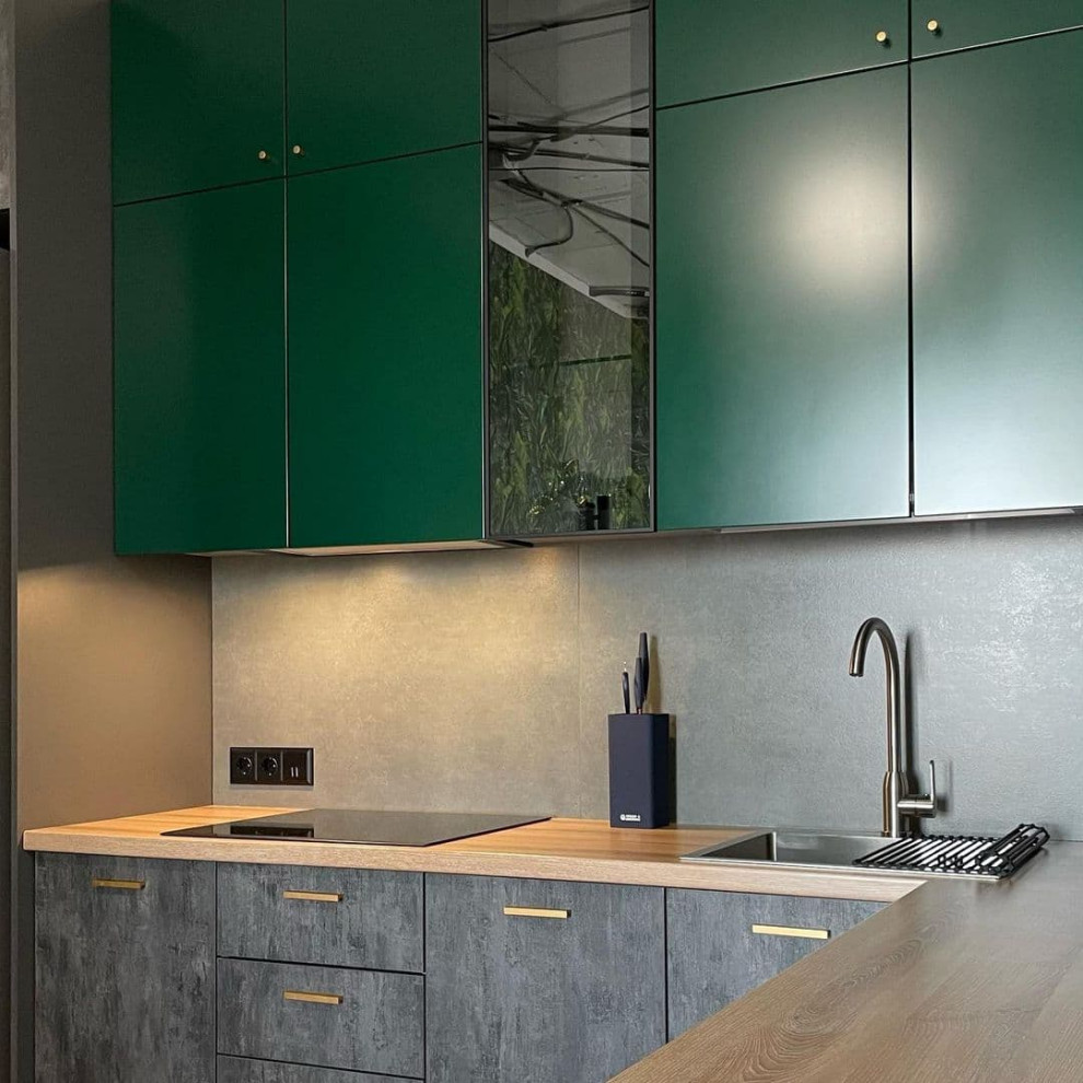 This is an example of a mid-sized transitional l-shaped separate kitchen in Other with a drop-in sink, flat-panel cabinets, green cabinets, wood benchtops, grey splashback, porcelain splashback, stainless steel appliances, ceramic floors, no island, yellow floor and brown benchtop.