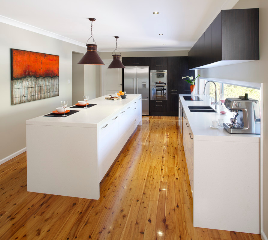 Design ideas for a large contemporary l-shaped separate kitchen in Sydney with a double-bowl sink, flat-panel cabinets, white cabinets, quartz benchtops, window splashback, stainless steel appliances, light hardwood floors and with island.