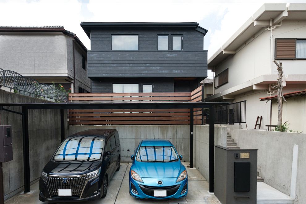 This is an example of a small scandinavian two-storey black house exterior in Nagoya with a hip roof, a metal roof and a black roof.