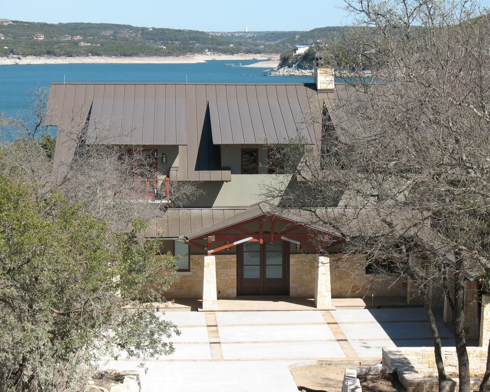 This is an example of a two-storey exterior in Austin with stone veneer and a gable roof.