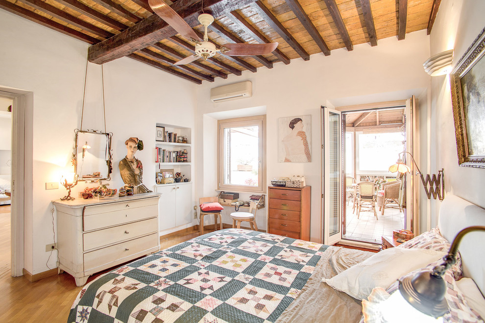 Photo of a mid-sized eclectic master bedroom in Rome with white walls, light hardwood floors and beige floor.