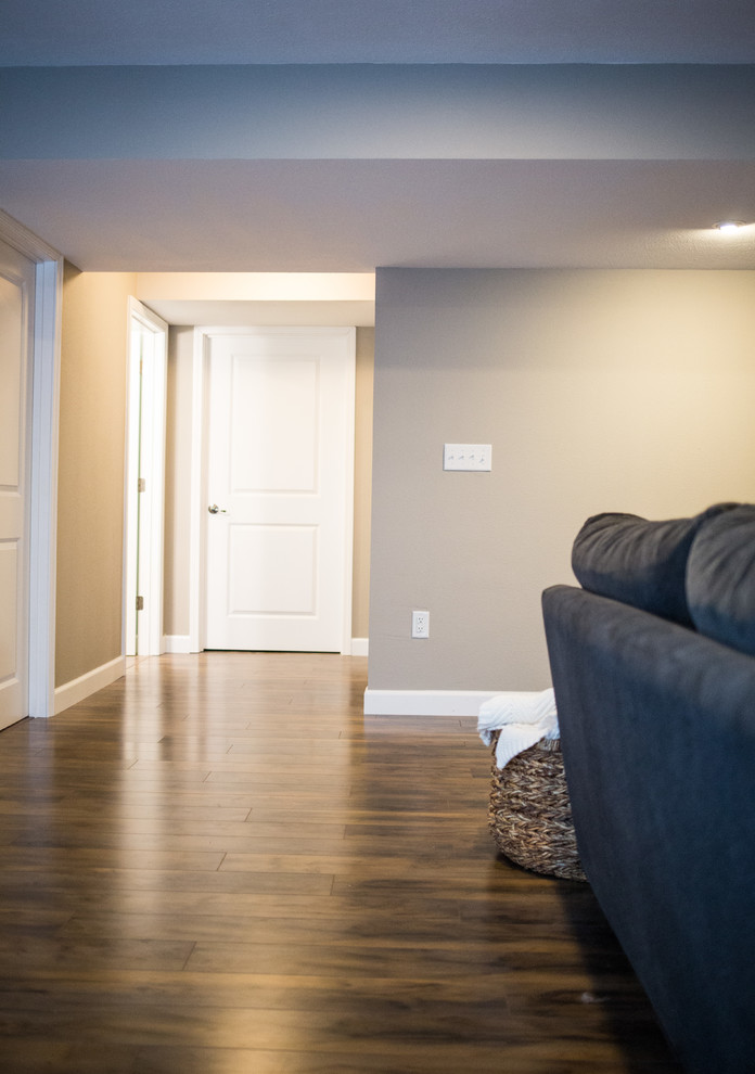 Basement - mid-sized rustic underground medium tone wood floor basement idea in St Louis with beige walls and no fireplace